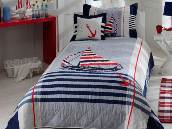 Couvre-lit de bébé sur le lit pour les garçons dans le style marin