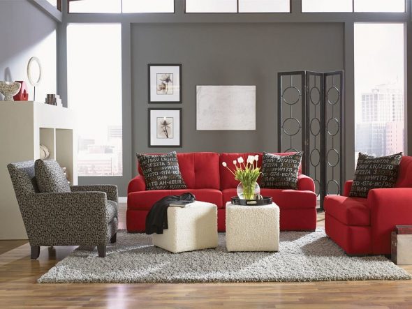 Sofa rouge droit à l'intérieur avec deux chaises