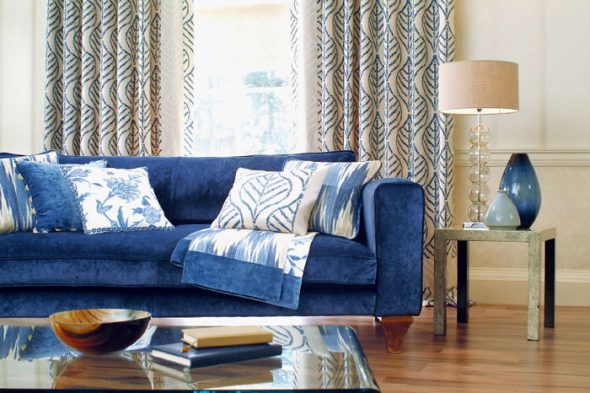combinaison d'un canapé bleu foncé avec un parquet en chêne et des murs couleur sable