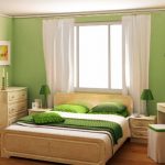 Chambre verte avec un lit près de la fenêtre