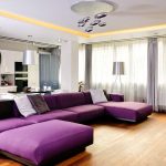 Grand canapé violet dans le salon-cuisine combiné