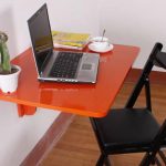 Table pliante orange pour travailler devant un ordinateur