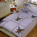 Couvre-lits tricotés dans des carrés de lit bébé