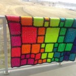 Couverture inhabituelle composée de carrés multicolores de différentes tailles aux couleurs de l'arc-en-ciel
