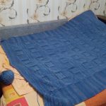 Une grande couverture tricotée bleue ira bien sur un lit ou un canapé