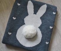 Couverture originale en laine tricotée avec une jolie application en forme de lapin