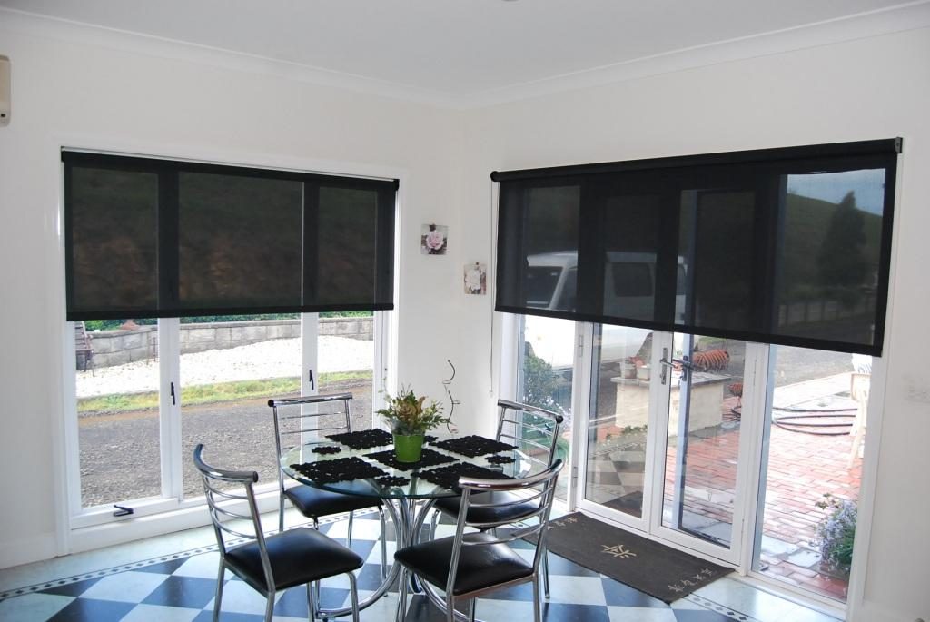 Rideaux noirs translucides sur la fenêtre de la cuisine avec des murs blancs
