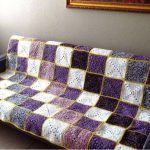 Belle couverture sur un canapé avec un motif en diagonale de carrés