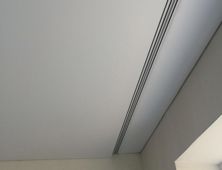 Profil en plastique de la corniche de plafond dans la niche devant la fenêtre