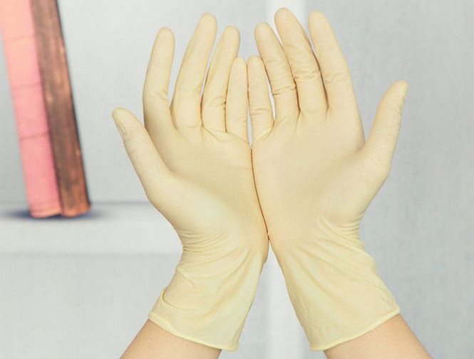 Les mains des ménagères dans des gants de caoutchouc