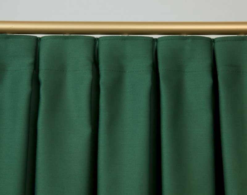 Des plis croisés sur le rideau de tissu vert foncé